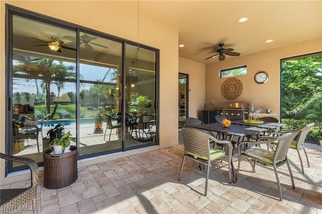 view of patio with outdoor dining space, a ceiling fan, and a grill