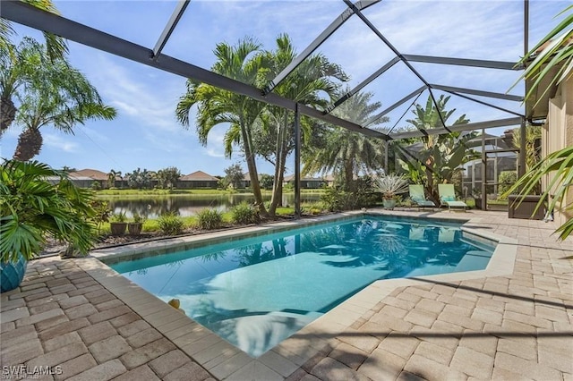 outdoor pool featuring glass enclosure, a patio, and a water view