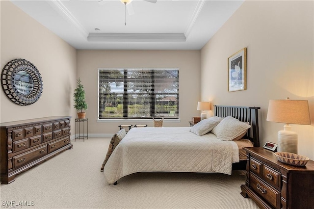 bedroom featuring a tray ceiling, baseboards, carpet flooring, and crown molding