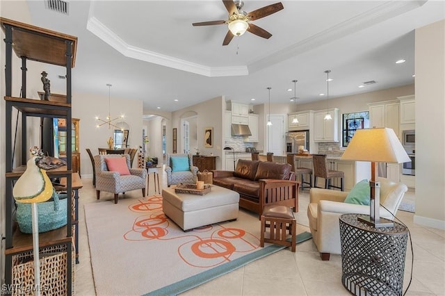 living room featuring visible vents, arched walkways, crown molding, light tile patterned floors, and a raised ceiling