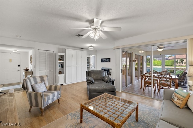 14987 Rivers Edge Ct Unit 139, Fort Myers, FL 33908 - living room with ceiling fan, a textured ceiling, and light wood-style floors