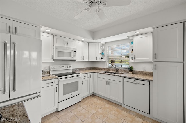 kitchen with white cabinets, a textured ceiling, sink, and white appliances