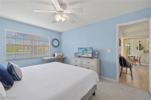 carpeted bedroom with a textured ceiling and ceiling fan