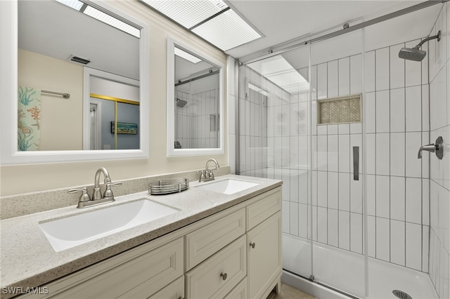 bathroom with a shower with shower door and vanity