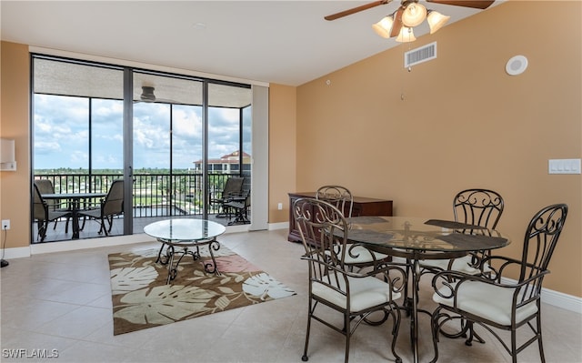 dining space with a wall of windows, light tile patterned floors, and ceiling fan