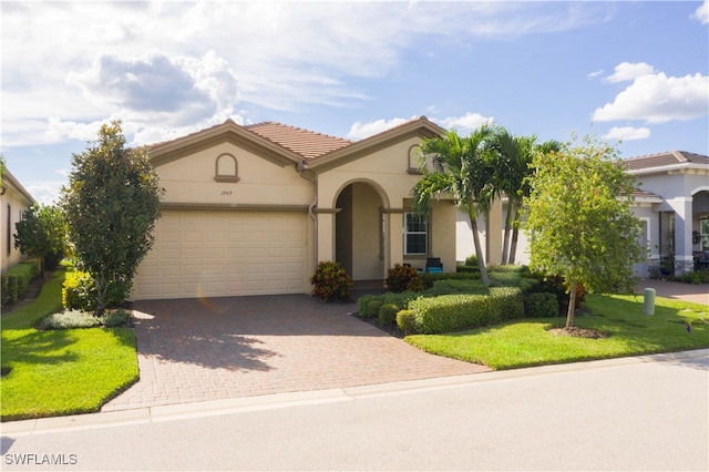 mediterranean / spanish house with a front lawn and a garage