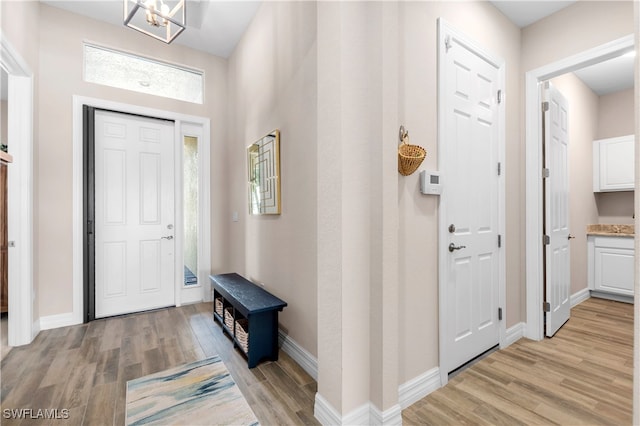 entrance foyer with light hardwood / wood-style floors and an inviting chandelier