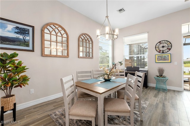 dining area with an inviting chandelier, dark hardwood / wood-style flooring, and plenty of natural light