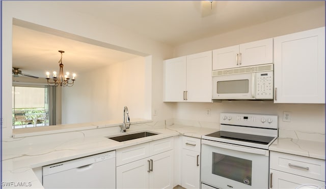 kitchen with an inviting chandelier, white appliances, white cabinetry, and sink