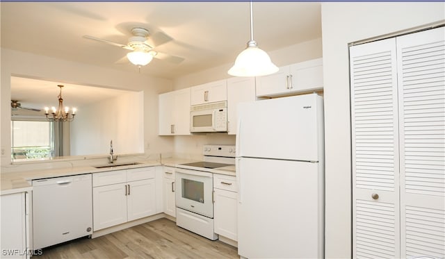 kitchen with pendant lighting, white appliances, white cabinetry, and sink