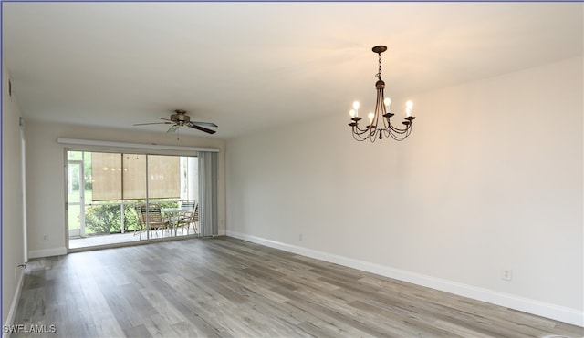 spare room featuring ceiling fan with notable chandelier and hardwood / wood-style flooring