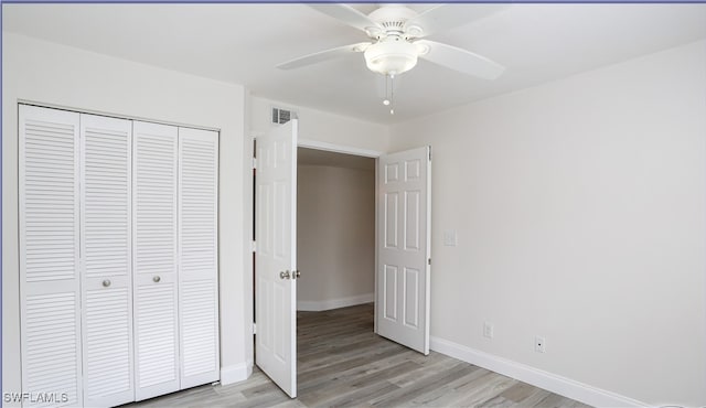 unfurnished bedroom featuring light hardwood / wood-style floors, ceiling fan, and a closet