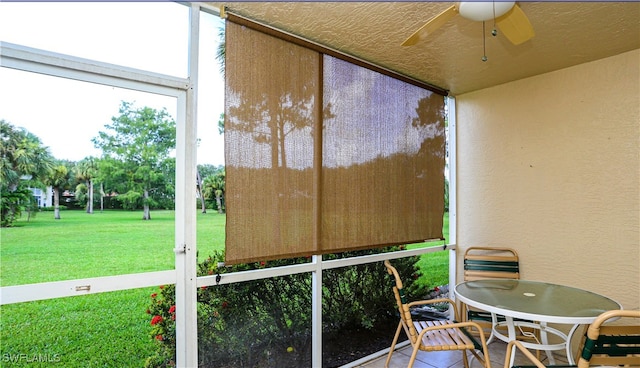 sunroom / solarium featuring ceiling fan