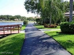 view of property's community with a yard and a water view