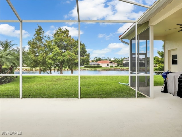 unfurnished sunroom featuring a water view and ceiling fan