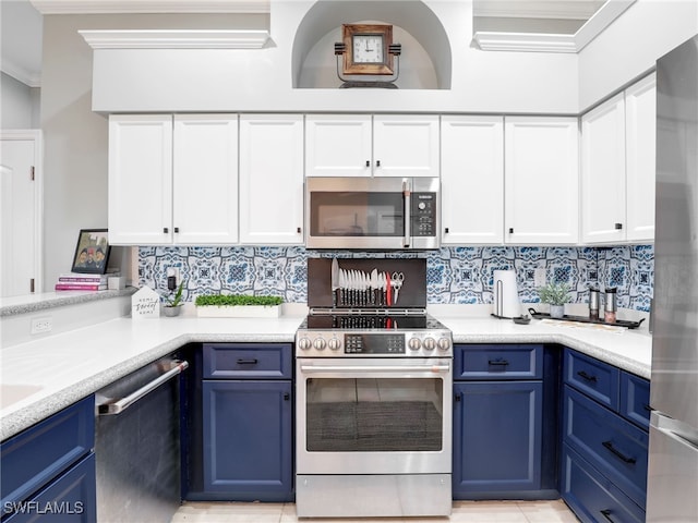 kitchen with blue cabinetry, decorative backsplash, appliances with stainless steel finishes, and ornamental molding