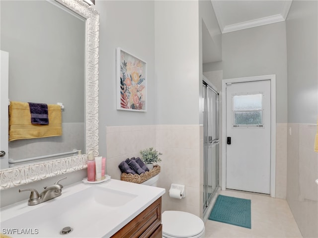 bathroom featuring tile patterned flooring, vanity, crown molding, toilet, and tile walls