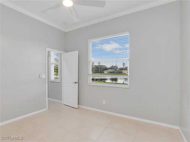 empty room with light tile patterned flooring, ceiling fan, crown molding, and plenty of natural light