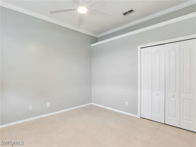 unfurnished bedroom with light tile patterned floors, ceiling fan, crown molding, and a closet