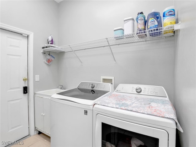 laundry area with cabinets, independent washer and dryer, and light tile patterned floors