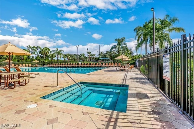 view of swimming pool featuring a hot tub and a patio area