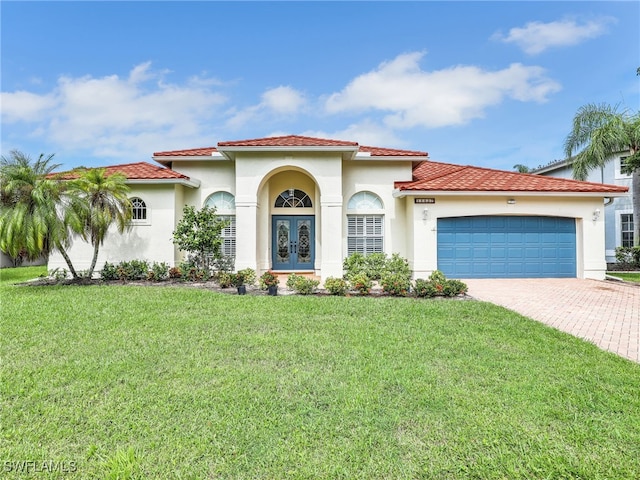 mediterranean / spanish-style home with a front yard, french doors, and a garage