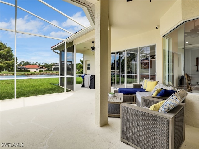 sunroom / solarium featuring a wealth of natural light, ceiling fan, and a water view