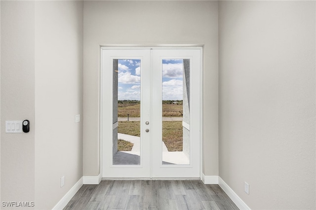 entryway featuring baseboards, wood finished floors, and french doors
