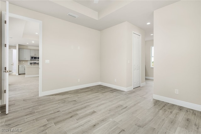 spare room featuring baseboards, visible vents, light wood-style floors, and recessed lighting