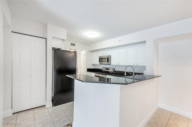 kitchen featuring white cabinets, kitchen peninsula, stainless steel appliances, and light tile patterned floors