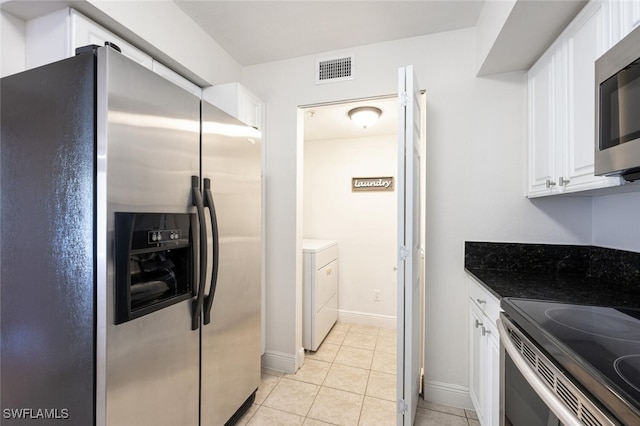 kitchen featuring washer / clothes dryer, light tile patterned floors, white cabinetry, and appliances with stainless steel finishes