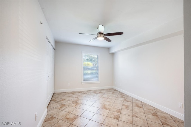 spare room with ceiling fan and light tile patterned flooring