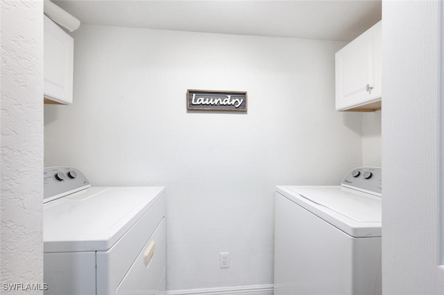 washroom with washer and clothes dryer and cabinets