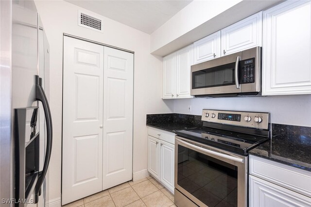 kitchen with white cabinets, light tile patterned flooring, and appliances with stainless steel finishes