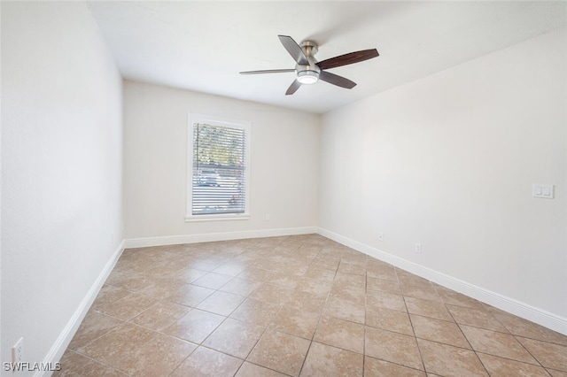 tiled spare room with ceiling fan