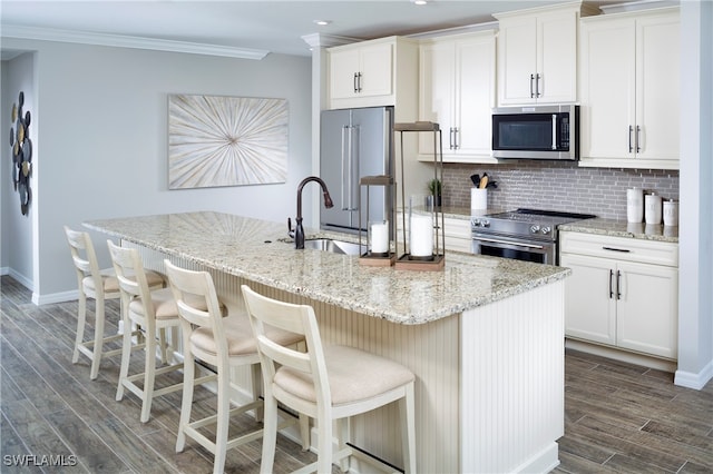 kitchen with white cabinets, sink, a center island with sink, stainless steel appliances, and dark hardwood / wood-style floors