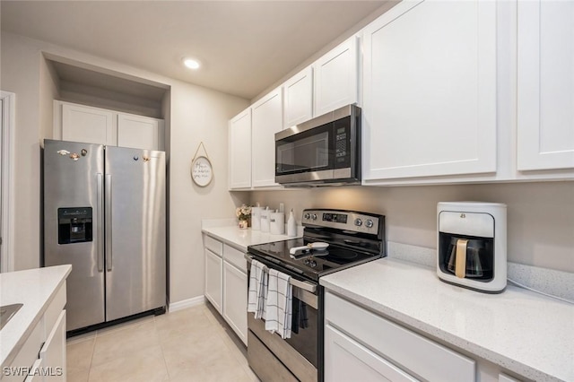 kitchen with stainless steel appliances, recessed lighting, light tile patterned floors, white cabinets, and light stone countertops