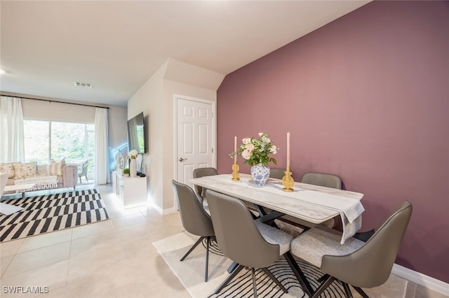 tiled dining room with vaulted ceiling