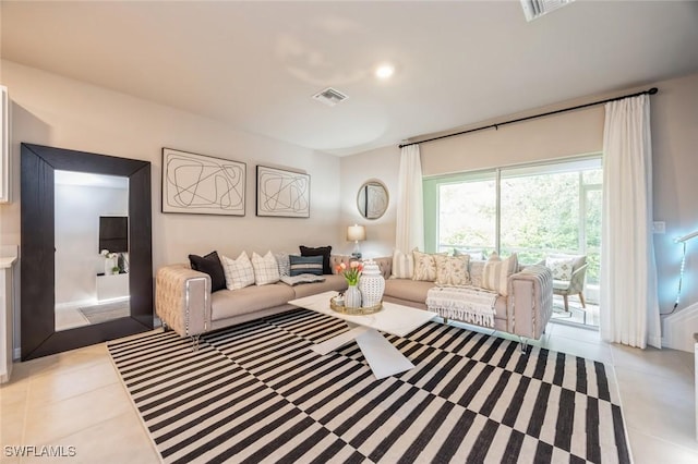 living area featuring light tile patterned flooring and visible vents