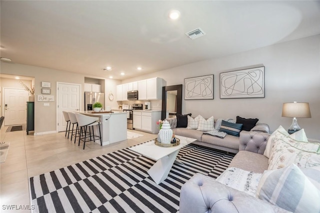 living area with light tile patterned flooring, baseboards, visible vents, and recessed lighting