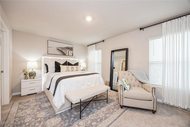 bedroom with light colored carpet and baseboards
