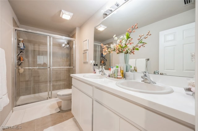 bathroom with vanity, tile patterned flooring, toilet, and a shower with door