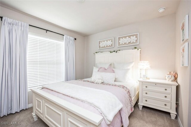 bedroom with light colored carpet and baseboards