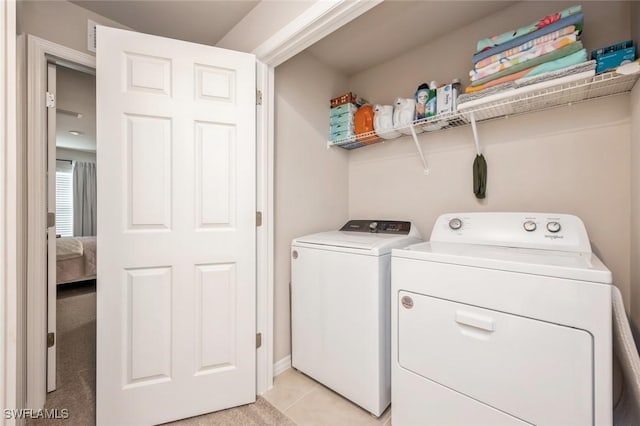 laundry area with washing machine and dryer, laundry area, and light tile patterned floors