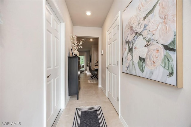 hallway featuring light tile patterned floors, baseboards, and recessed lighting