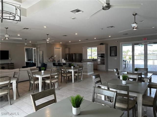 dining space with ornamental molding, visible vents, and ceiling fan