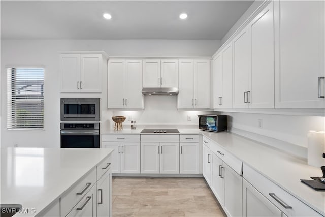 kitchen featuring white cabinetry, light hardwood / wood-style floors, and stainless steel appliances