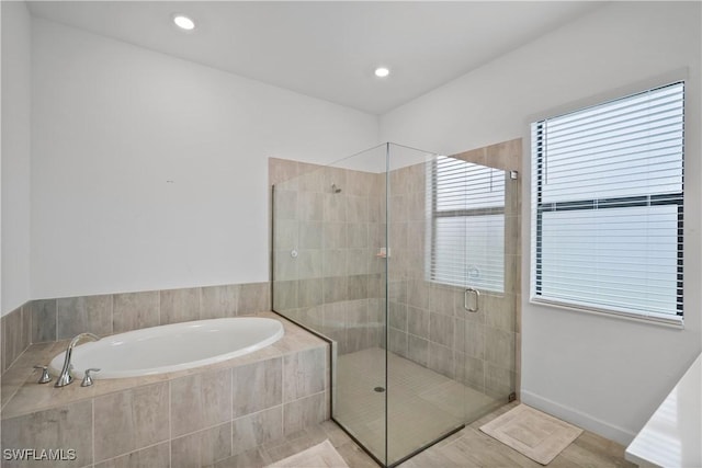 full bath with a stall shower, recessed lighting, and a bath