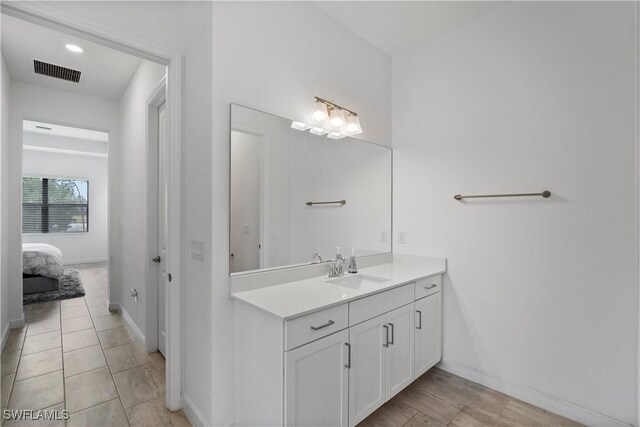 bathroom featuring ensuite bath, visible vents, baseboards, and vanity