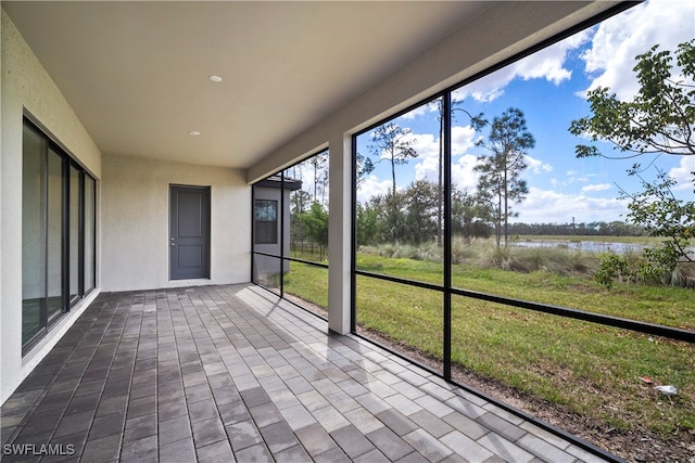 unfurnished sunroom with a water view